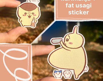 Puede incluir: Se muestran dos pegatinas. Una es un personaje de dibujos animados amarillo que sostiene una botella. La otra es un conejo de dibujos animados amarillo que sostiene una sierra. También es visible el texto "kurimanju + fat usagi sticker".