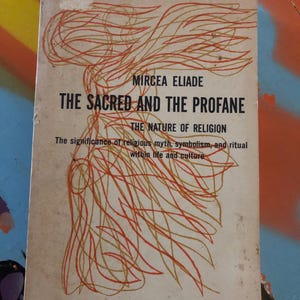 May include: Vintage paperback book titled "The Sacred and the Profane" by Mircea Eliade. The cover features an abstract design in orange and brown over a cream background. The book's title and author are in bold black text.