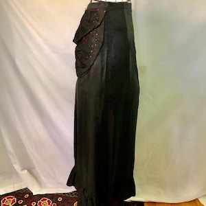 May include: A black skirt with a red and black polka dot ruffle detail at the waist.