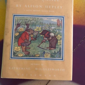 May include: A vintage book titled "Toad's Castle" by Alison Uttley. The cover features an illustration of a frog and a mole in a garden setting. The book is a "Little Brown Mouse Book" with pictures by Katherine Wigglesworth.