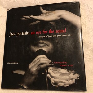 May include: A black and white hardcover book titled Jazz Portraits: An Eye for the Sound, Images of Jazz and Jazz Musicians by Tim Motion with a foreword by Ronnie Scott. The cover features a photograph of a singer holding a microphone.