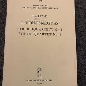 May include: A vintage music score titled "String Quartet No. 1" by Bartók. The cover is off-white with black text and a small illustration of a musician. The text includes "Pocket Scores" and "Editio Musica Budapest".