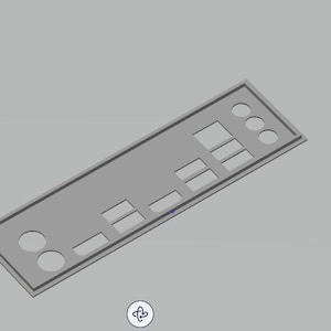 Op de afbeelding: Een grijs computeronderdeel met rechthoekige en cirkelvormige uitsparingen. Het onderdeel heeft een rechthoekig frame en staat tegen een grijze achtergrond. Het lijkt een achterpaneel voor een computer te zijn.