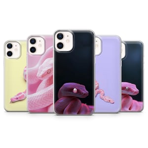 May include: A collection of phone cases featuring images of snakes. The cases display various snake species in shades of pink, purple, and yellow against solid backgrounds. The cases are designed to fit a smartphone.