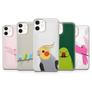 May include: Five phone cases with bird designs. The cases feature a pink parrot, a row of small birds on a branch, a cockatiel, a green parrot, and a pink parrot with feather accents. The cases are in various colors, including pink, green, and white.