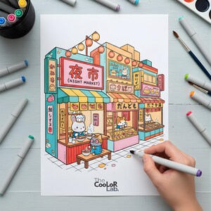 以下が含まれることがあります： 漫画の動物のキャラクターが登場する、日本の夜市のカラフルなイラスト。 「Night Market」など、日本語と英語の看板があるお店が描かれています。 手がマーカーで画像を塗り、他のマーカーや画材が近くにあります。