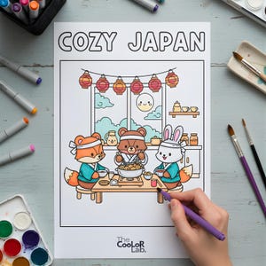 以下が含まれることがあります： 「COZY JAPAN」の文字が上部にある塗り絵。イラストには、キツネ、クマ、ウサギの3匹の漫画の動物が、食事を楽しんでいる様子が描かれています。日本のスタイルの部屋で、提灯が飾られています。