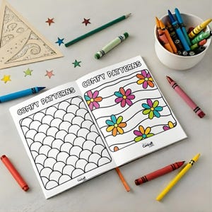 May include: An open coloring book with the words "COMFY PATTERNS" on the cover, featuring flower and scale designs. Crayons, colored pencils, and star-shaped confetti surround the book, with a small bowl of crayons in the background.