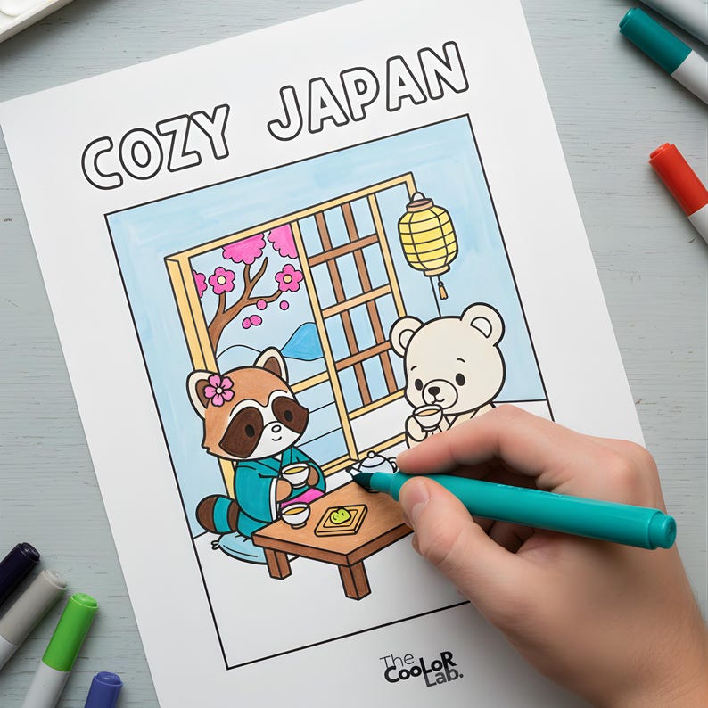以下が含まれることがあります： 「COZY JAPAN」の文字が上部にある塗り絵。イラストは、日本のスタイルの部屋でお茶を飲むアライグマとクマを描いています。手はターコイズ色のマーカーで画像を塗っています。Coolor Labのロゴが下にあります。