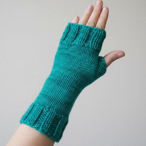 Peut inclure: Un mitaine tricotée de couleur turquoise. La mitaine est faite d'un fil doux et présente un poignet côtelé et une ouverture pour le pouce. La texture tricotée est visible sur toute la mitaine, conçue pour garder la main au chaud tout en laissant les doigts libres.