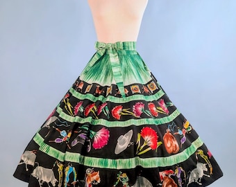 Può includere: Una gonna vintage a cerchio intero su un manichino. La gonna presenta una fascia verde con fiocco, che si trasforma in una gonna nera con strisce orizzontali verdi. Le sezioni nere sono decorate con immagini colorate di tori, toreri e fiori.