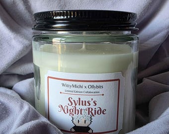 May include: A clear glass jar candle with a black lid. The candle has a white label with the text "WittyMichi x Ollybits Limited Edition Collaboration" and "Sylus's Night Ride". The candle is 8 oz Soy Wax.