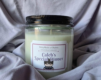 May include: A glass jar candle with a black lid, labeled "Caleb's Special Dinner." The label features pixel art and the text "WittyMichi x Ollybits." The candle is 8 oz and made of soy wax.