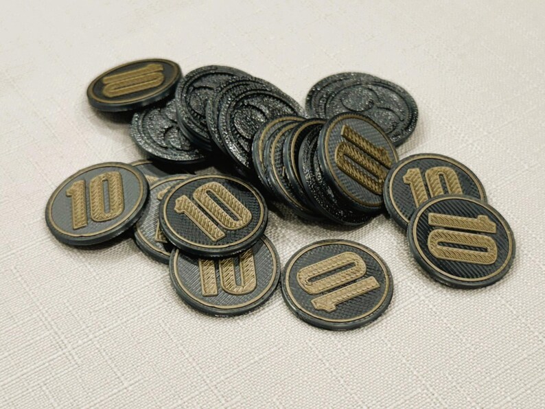 A pile of silver, circular game coins worth ten coins. The coins have a raised "10" on the front and a submerged symbol on the back. These premium board game coins replace the standard card board coins.