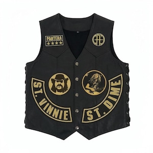 May include: A black leather vest featuring gold embroidered patches, including the text Pantera, St. Vinnie, and St. Dime. The vest has a V-neck, silver-tone snap buttons down the front, and black lace-up side details with circular portrait patches.
