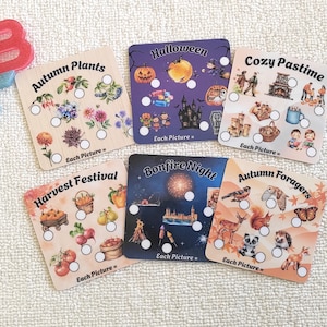May include: Five square activity cards with seasonal themes including Autumn Plants, Halloween, Cozy Pastime, Harvest Festival, Bonfire Night, and Autumn Foragers. Each card features illustrations, white circles for tracking, and the text Each Picture =.