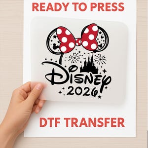 May include: A clear DTF transfer with a red polka dot bow, Mickey Mouse ears, and the word "Disney" with the year "2026". The words "READY TO PRESS" and "DTF TRANSFER" are printed in red.