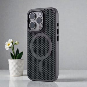Op de afbeelding: Donkergrijze telefoonhoes met een honingraatpatroon en een cirkelvormig ontwerp op de achterkant. De hoes heeft een opstaande rand rond de cameralenzen en de tekst "#BRACKET" is zichtbaar. Ontworpen om een smartphone te beschermen.
