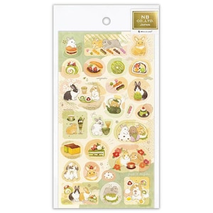 May include: A sheet of decorative stickers featuring illustrations of rabbits and Japanese sweets. The stickers are in various shapes and sizes, with a color palette of green, white, and brown. The text "NB CO., LTD. JAPAN" is printed on the top right.