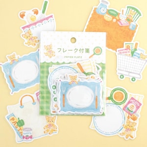 May include: A collection of cute, illustrated stickers featuring a cooking theme. The stickers include plates, shopping carts, and cooking utensils, with a repeating pattern of a small cat. The packaging has Japanese text.