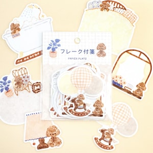 May include: A collection of decorative stickers featuring teddy bears and balloons. The stickers are in various shapes, including a bathtub, a rocking horse, and a window. The color palette includes brown, white, and yellow. The package has Japanese text.