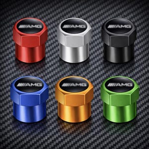 May include: Set of six metallic tire valve stem caps in red, silver, black, blue, gold, and green. Each cap features a black top with the "AMG" logo in white. The caps have a hexagonal design and a shiny finish.