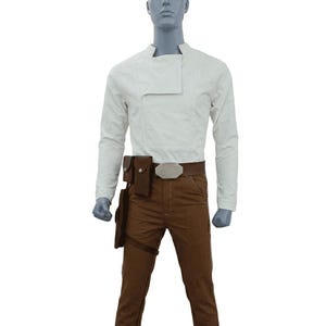 Può includere: Un costume composto da una camicia bianca a maniche lunghe con colletto asimmetrico, pantaloni marroni e una cintura marrone con fibbia argentata. Il costume include una fondina e una tasca marroni.