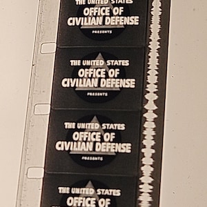 May include: A strip of film with multiple frames. Each frame displays the text "THE UNITED STATES OFFICE OF CIVILIAN DEFENSE PRESENTS" in white against a black background. The film strip has sprocket holes along one edge.