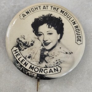 May include: Vintage pin featuring a black and white image of Helen Morgan, with the text "A Night at the Moulin Rouge" and "Helen Morgan" in a circular design. The pin has a metal pin backing.