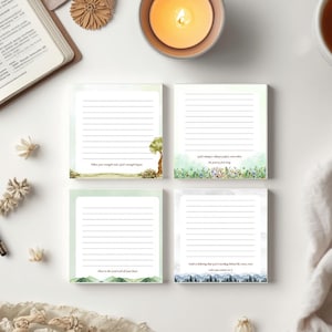 Può includere: Quattro blocchetti di foglietti adesivi quadrati con carta a righe, ognuno caratterizzato da un'illustrazione paesaggistica ad acquerello unica sul fondo. I disegni includono un albero, un prato fiorito, colline verdi e una catena montuosa.