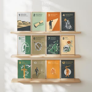 Könnte beinhalten: Ein Satz von zwölf gerahmten Kunstdrucken, die auf Holzregalen ausgestellt sind. Jeder Druck zeigt eine minimalistische Illustration mit einer Nummer und einem Titel, wie "Ordinary World" und "Call to Adventure". Die Farbpalette umfasst Grün-, Orange- und Beigetöne.