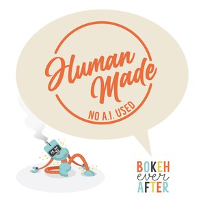 May include: A graphic illustration featuring a light blue robot with orange limbs and X-shaped eyes emitting smoke from its head. Above the robot is a large beige speech bubble containing the orange text Human Made NO A.I. USED. Below is BOKEH ever AFTER.