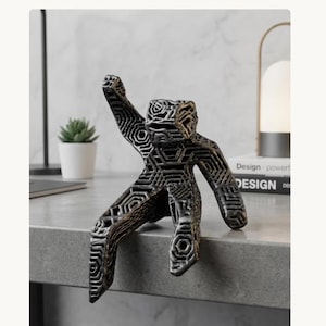 May include: A bronze-colored, geometric sculpture of a person in a seated position with one arm raised. The sculpture has a hollow, open design with a repeating pattern. The figure is placed on a gray surface.