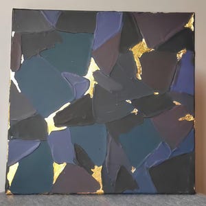 Könnte beinhalten: Quadratisches abstraktes Gemälde mit strukturierter Oberfläche. Das Kunstwerk zeigt ein Mosaik aus dunkelblauen, grauen und violetten Formen, akzentuiert mit Blattgold. Das Stück ist auf einer quadratischen Leinwand montiert.