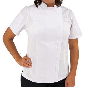 May include: A white chef's coat with short sleeves and a mandarin collar. The coat features a diagonal closure with a row of stitching down the front and a small pocket on the left sleeve. The person is wearing black pants.