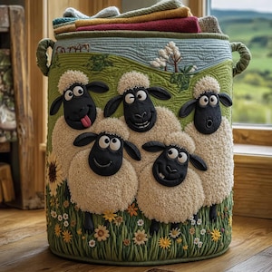 May include: A whimsical, cylindrical storage basket featuring a charming sheep design. The basket is adorned with five smiling sheep against a green field background, with colorful flowers and a blue sky. The top is filled with folded textiles.