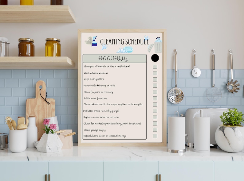 May include: A framed cleaning schedule titled "CLEANING SCHEDULE" with the word "ANNUALLY" in large text. The schedule lists tasks like washing windows and cleaning gutters. The background shows a kitchen setting with various utensils.