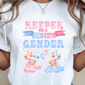 May include: White t-shirt with the text "KEEPER OF THE GENDER" in pink and blue. The shirt features illustrations of teddy bears on clouds with balloons, perfect for a gender reveal or baby shower.