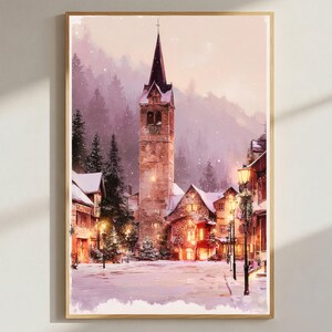May include: A vertical wall art print depicting a snowy village square at twilight. A tall stone church tower stands centrally, surrounded by snow-covered houses and evergreen trees. Warm yellow light glows from windows and street lamps.