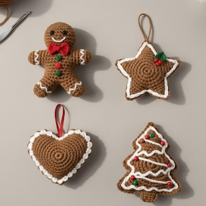 Puede incluir: Cuatro adornos navideños de ganchillo hechos a mano: un hombre de jengibre con pajarita roja, una estrella con ribete blanco, un corazón con cinta roja y un árbol de Navidad con adornos rojos y verdes. Todos son marrones con detalles blancos y rojos.