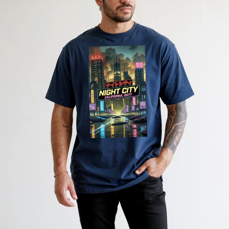 Op de afbeelding: Marineblauw T-shirt met een levendige afbeelding van een futuristisch stadslandschap 's nachts. Het ontwerp bevat neonreclame, wolkenkrabbers en de tekst "NIGHT CITY CALIFORNIA, 2077". Het shirt heeft een klassieke ronde hals.