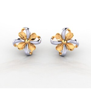 Op de afbeelding: Een paar oorstekers met een vierbladige bloemvorm. De oorbellen hebben een gouden midden en goudkleurige bloemblaadjes, met zilverkleurige accenten. De sieraden zijn geplaatst tegen een witte achtergrond.