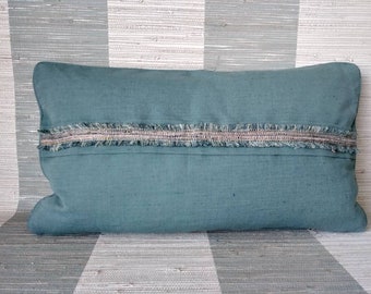 Fringe trimmed pillow cover. Anna French dyed wheat in the color petrol.