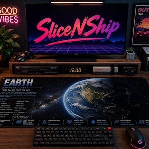 May include: A rectangular desk mat featuring a detailed graphic of Earth from space, including scientific data, facts, and icons. The mat displays the text "EARTH OUR HOME PLANET" and "THIRD PLANET FROM THE SUN" in white and blue lettering on a dark background.