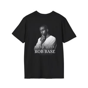 May include: Black t-shirt with a black and white portrait of a person and the text "LONG LIVE ROB BASE" beneath. The tee has short sleeves and a crew neck.