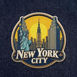 May include: Embroidered patch featuring a New York City design. The patch showcases the Statue of Liberty, skyscrapers, and the Empire State Building against a yellow sun. The words "NEW YORK CITY" are arched across the bottom.