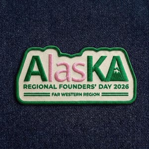 May include: Embroidered patch with the word "Alaska" in green and pink, featuring a mountain graphic. The patch includes the text "REGIONAL FOUNDERS' DAY 2026" and "FAR WESTERN REGION" on a white background, with a green border.