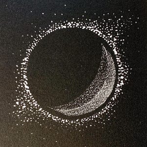 May include: Black and white art print featuring a crescent moon within a dotted circle against a dark background. The print is numbered 1/50 and includes the text "IMBOLE 2025". The artwork is on white paper.