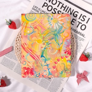 May include: A colorful floral design on a tablet case. The case features a vibrant mix of yellow, pink, blue, and green hues with floral and heart motifs. The text "NOTHING IS POSSIBLE TO" is visible in the background.