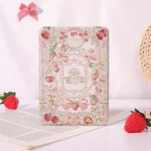 May include: A rectangular notebook with a pastel colour scheme, featuring a strawberry and bunny illustration. The cover is decorated with strawberries, bows, and floral designs. A red and white checked bow is visible in the background. The design has a vintage, whimsical aesthetic.